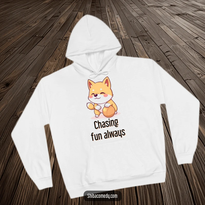 Funny Shiba Inu hoodie showing a playful dog with a mischievous glint nudging a rolling toy, perfect for active days.