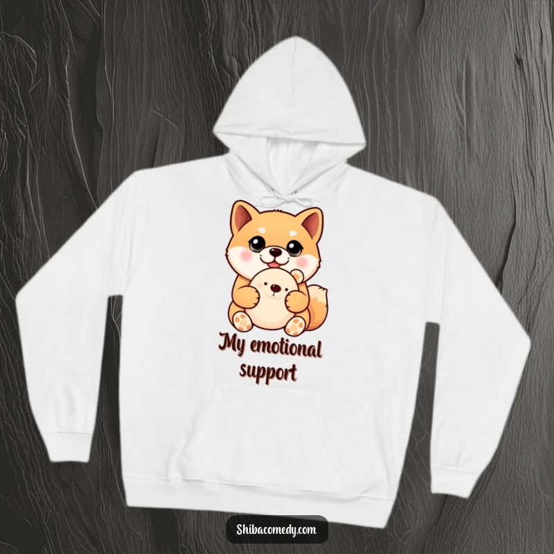 Funny Shiba Inu hoodie depicting a sweet dog with large, pleading eyes, cradling a plush toy, ideal for cozying up.