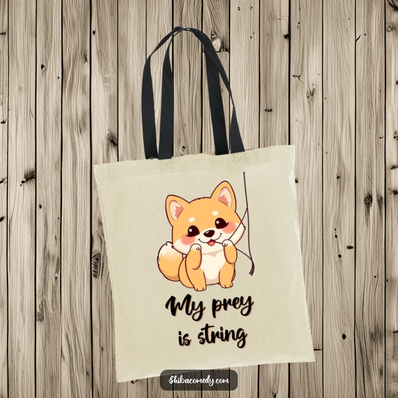 Funny Shiba Inu tote bag with a dog gleefully batting at a dangling string, highlighting playful antics and bright eyes.